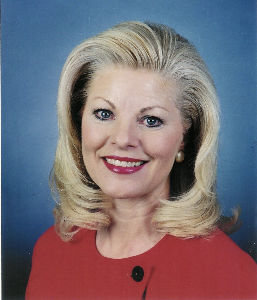 A woman with blonde hair and red shirt.